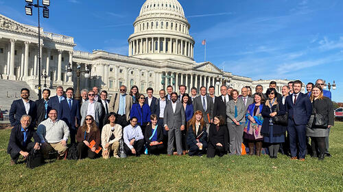 group of people standing in front of Washington, D.C. Capitol building.