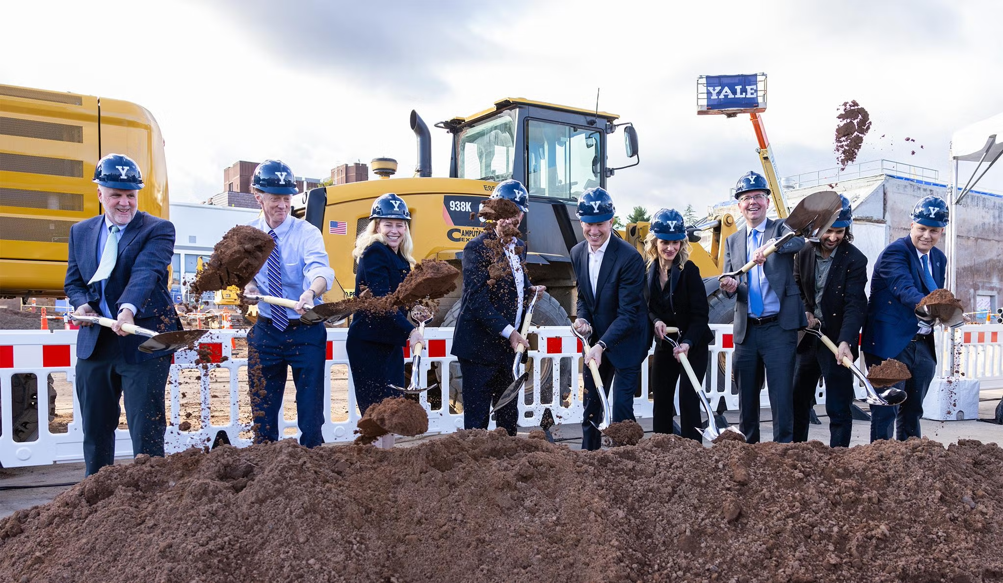 Line of people in hard hats and shovels at Yale Upper Science Hill groundbreaking ceremony.
