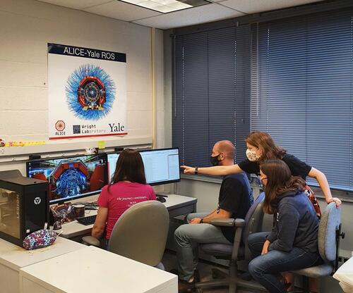 group of people looking at computers and pointing.