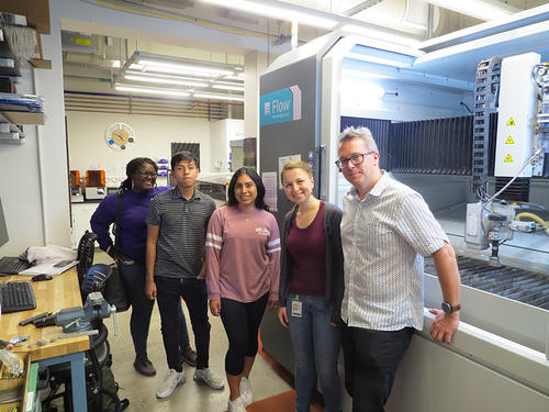 people standing in front of water jet cutter