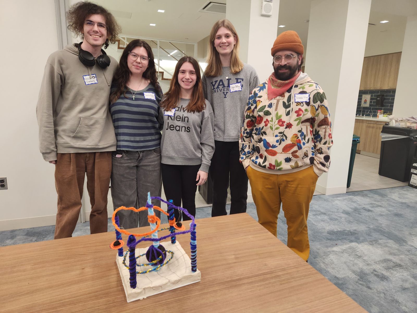 people standing smiling with art in front of them.