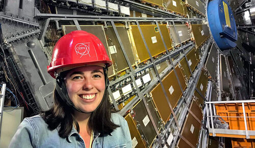 person standing in front of large equipment with hard hat on.