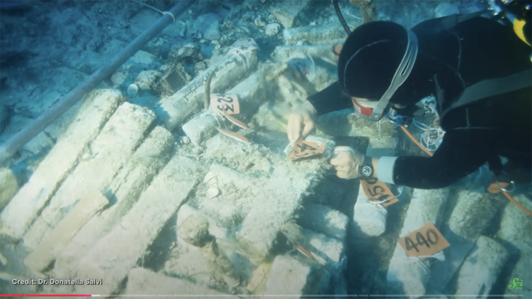 person scuba diving over lead ingots.