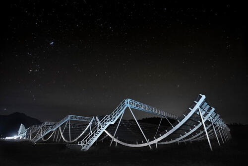 Set of radio telescope structures at night.