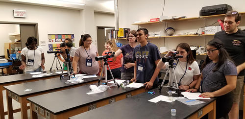 students looking through telescopes