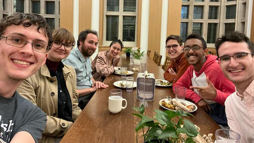 7 people smiling at a long table