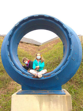 kids in sculpture of portal