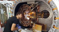 person working on large telescope.