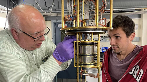 two people working on a cryostat.