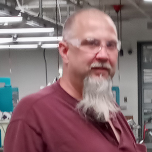 headshot of Tom Hurteau in machine shop.