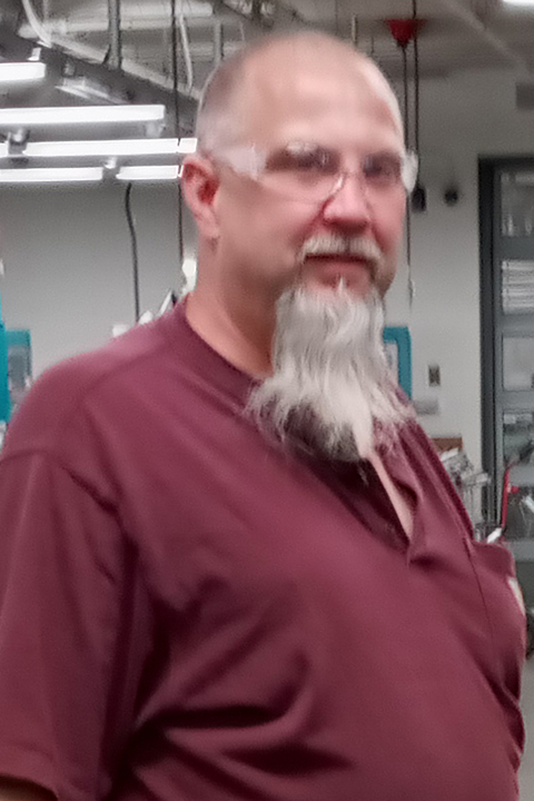 headshot of Tom Hurteau in machine shop.