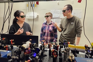 Wright Lab faculty member mentoring two people in a lab.