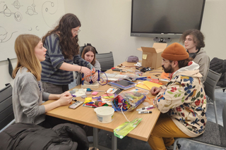 group of people at a table doing art for Visualize Science competition.