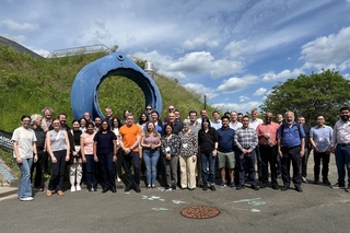 ALICE USA collaboration in front of Wright Lab blue, circular portal sculpture outside.