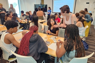 Pathways to Science Outreach event at Wright Lab with large group of people sitting at tables doing an activity.