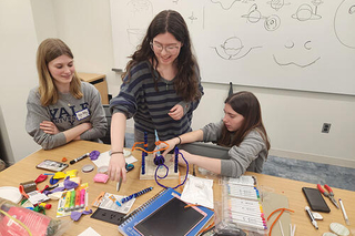 3 people working at visualize science event