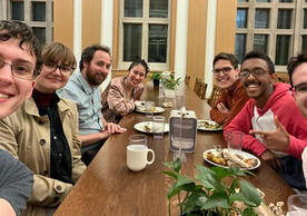 7 people smiling at a long table