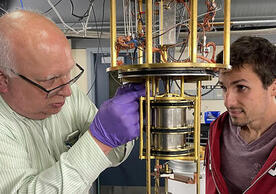 two people working on a cryostat.