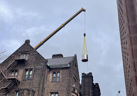crane lifting magnet over building.