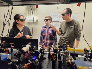 Wright Lab faculty member mentoring two people in a lab.
