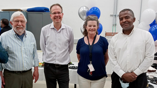 four people standing, smiling, at the Wright Lab 5-year anniversary celebration.