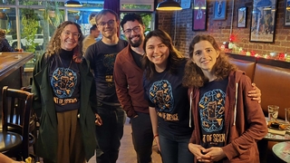 5 Coordinators of Pint of Science posing for a picture and smiling.