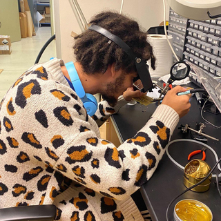 Student sitting at lab table using equipment.