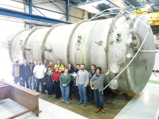 Group of people infront of part of MicroBooNE at Wright Lab.