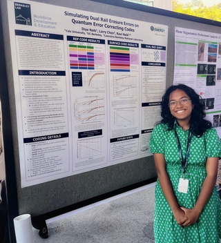 Diya Naik standing in front of poster.