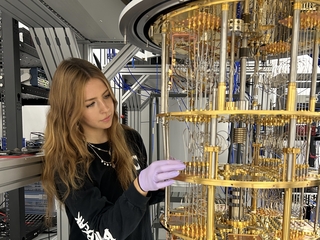 Vasilisa Malenkiy working in lab on experiment with golden, circular frame.