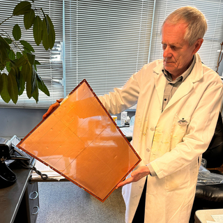 Nikolai Smirnov holding screen at Wright Lab that goes into a detector.