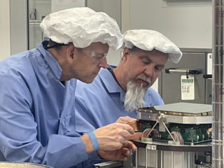 Tom Hurteau and Mark Haeckel in clean room working on QUEST camera.
