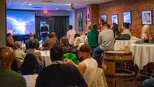 Sarah Demers giving talk to crowded room in Trinity bar.