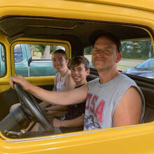 3 people in a yellow vehicle.
