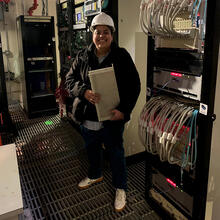 person standing in lab with equipment and hard hat