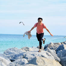 person walking by the sea.