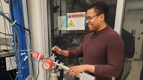 Image credit: Yale Wright Laboratory/Victoria Misenti Tyler Johnson working on an instrument for the RAY experiment.