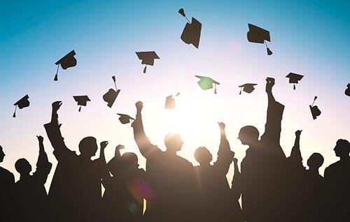 shadows of graduates throwing caps.