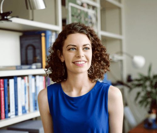 headshot of person in front of bookshelves.